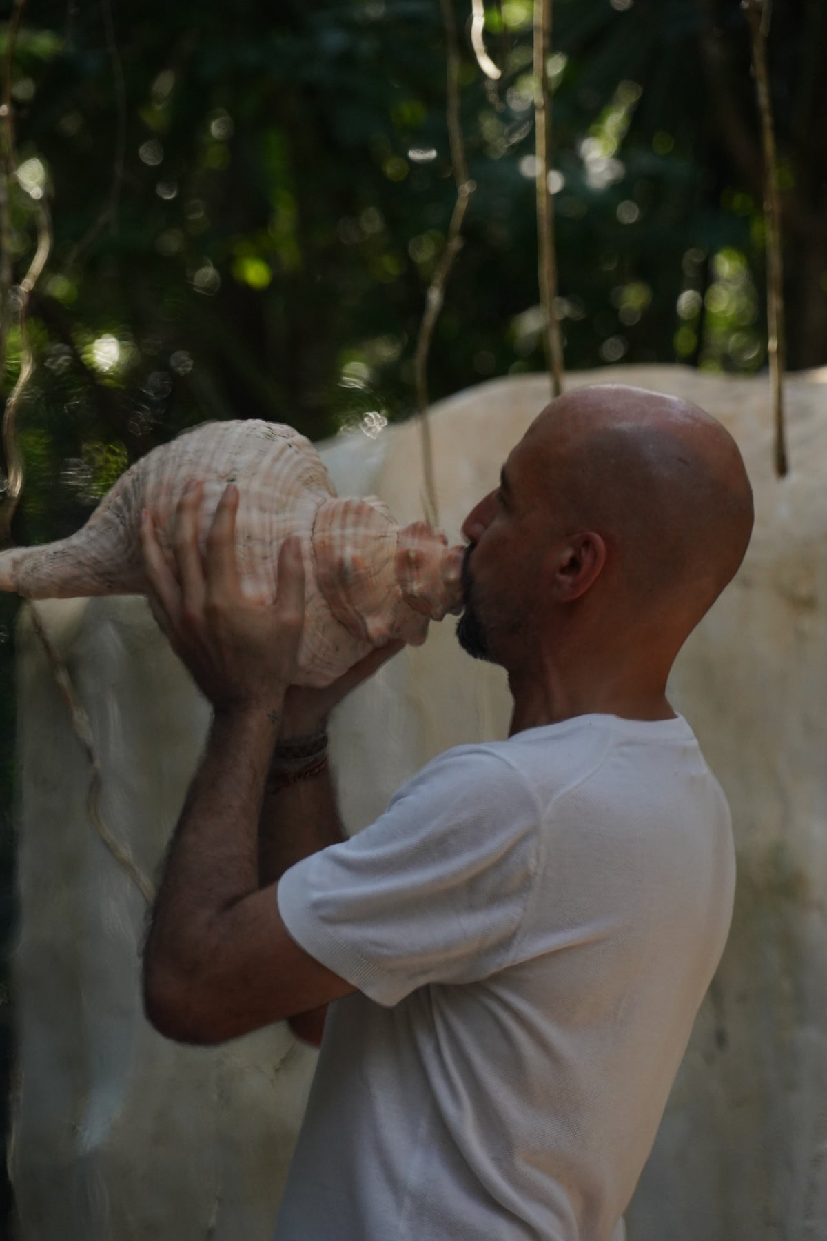 Participante tocando un caracol ceremonial.