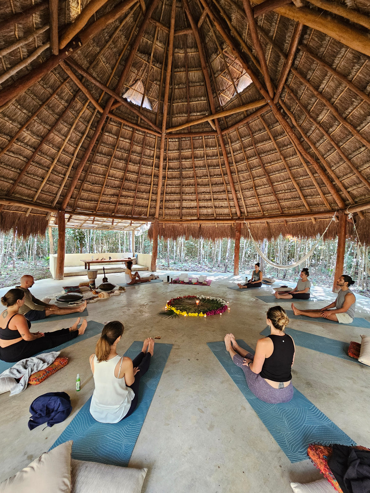 Práctica de yoga en círculo bajo la palapa.