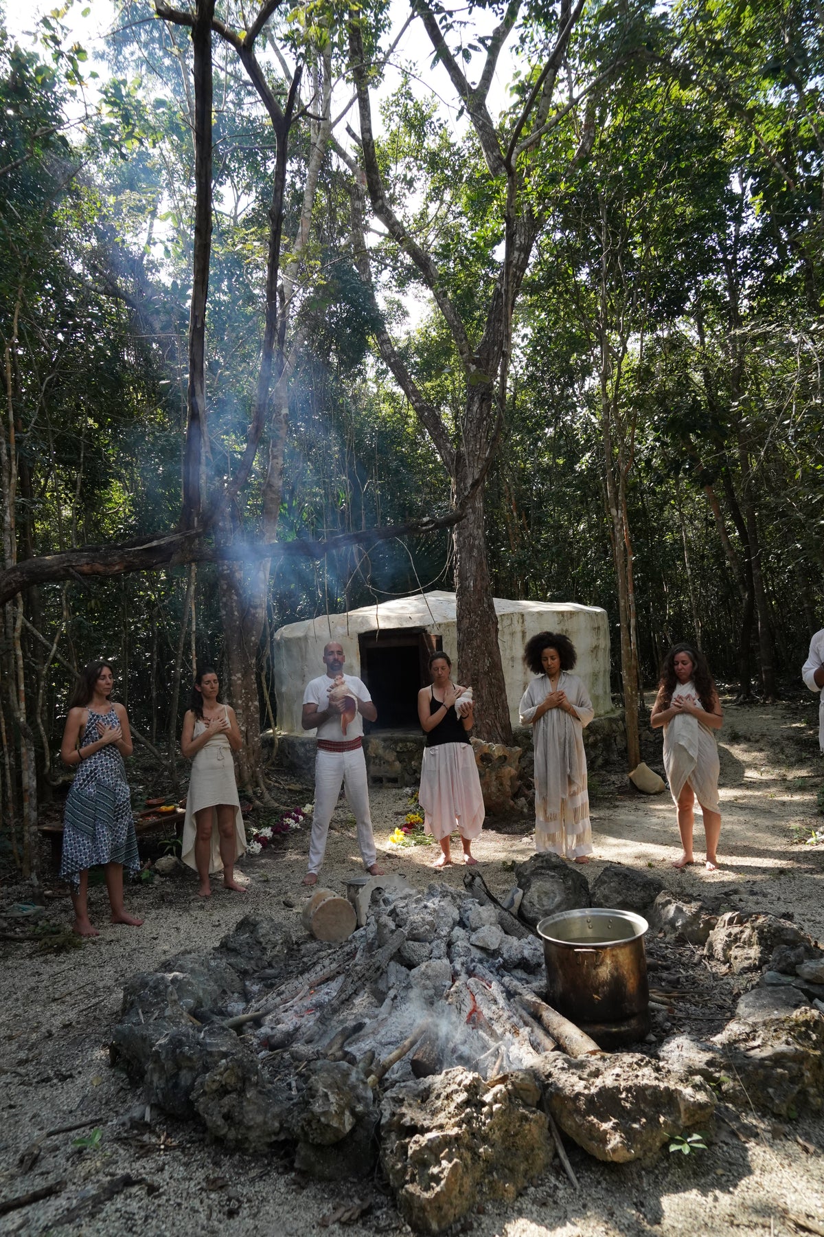 Grupo con las manos sobre el corazón durante una ceremonia junto al temazcal.